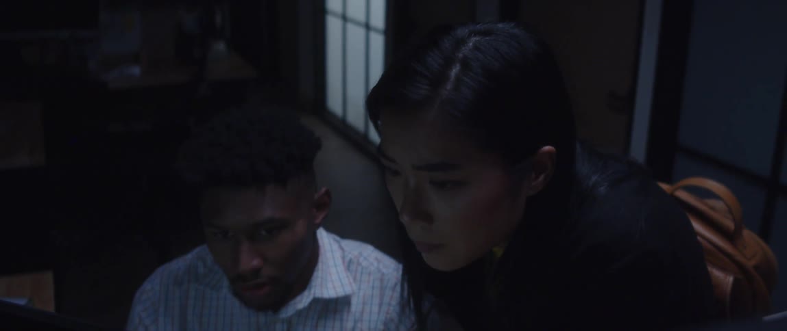 A male and female coworker looking at a computer monitor in an office setting
