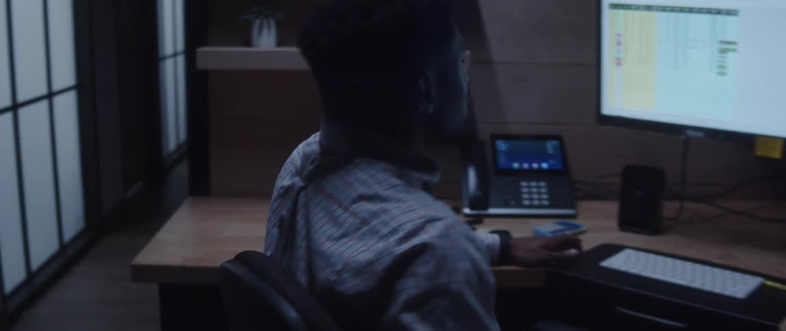 A man sitting at his desk sitting back and spinning in his chair looking frustrated