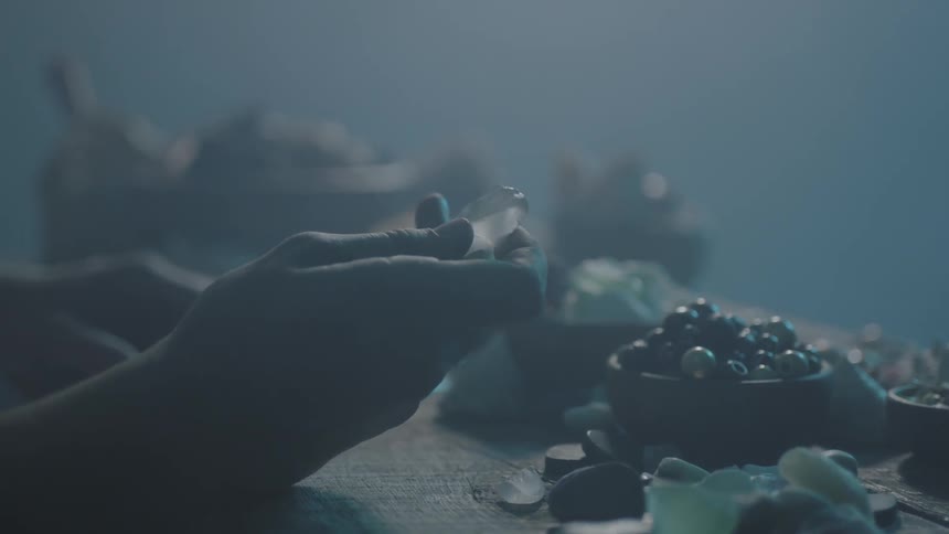Hands reach for a stone on a table