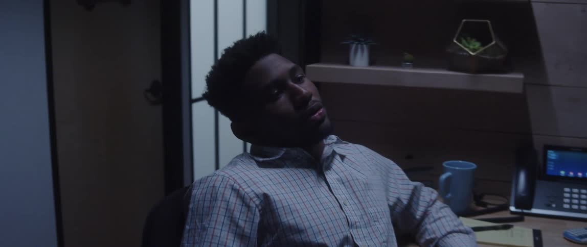 An man sits in his chair and spins around looking stressed and frustrated