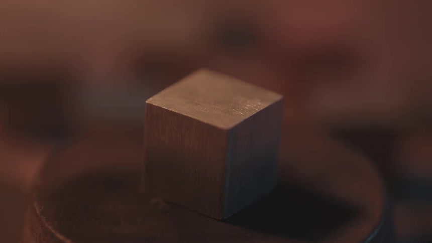 A small wooden cube sits on display