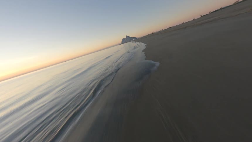 A sandy ocean beach at sunrise