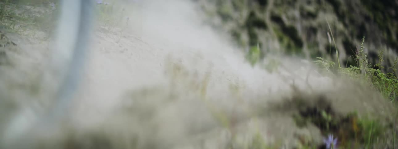 Cyclist rides bicycle on dirt track in the field