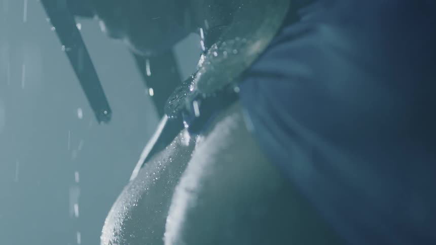 A man stands in the rain with a helmet on