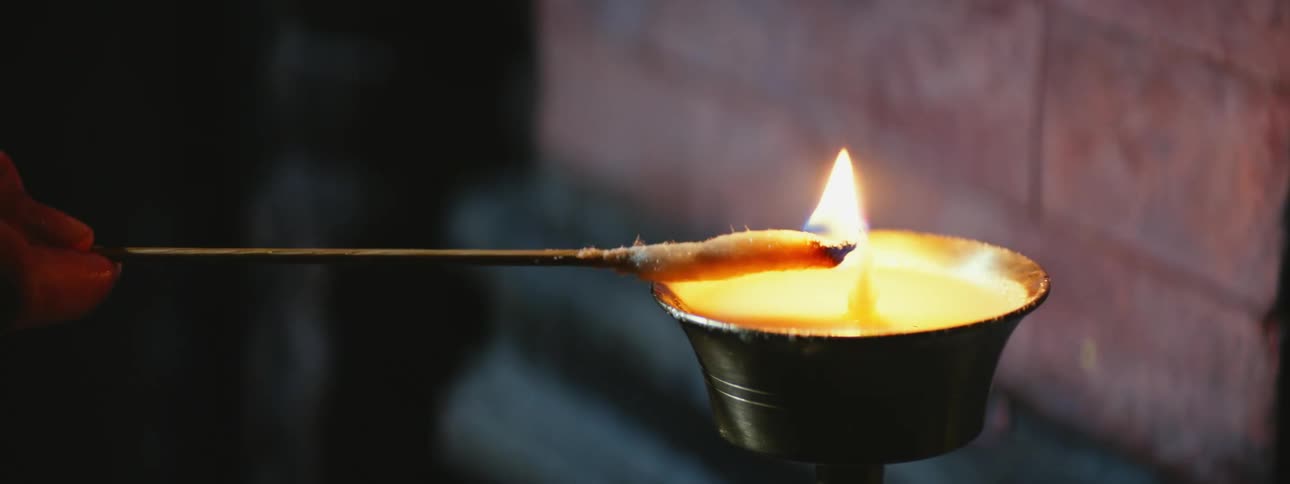 Gentle Hand Lighting a Candle Up Close