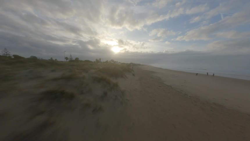 An aerial view of a sandy beach on a cloudy summer day