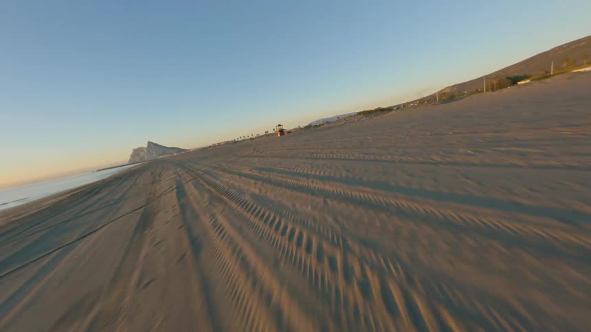 An aerial view of a drone flying over a beach