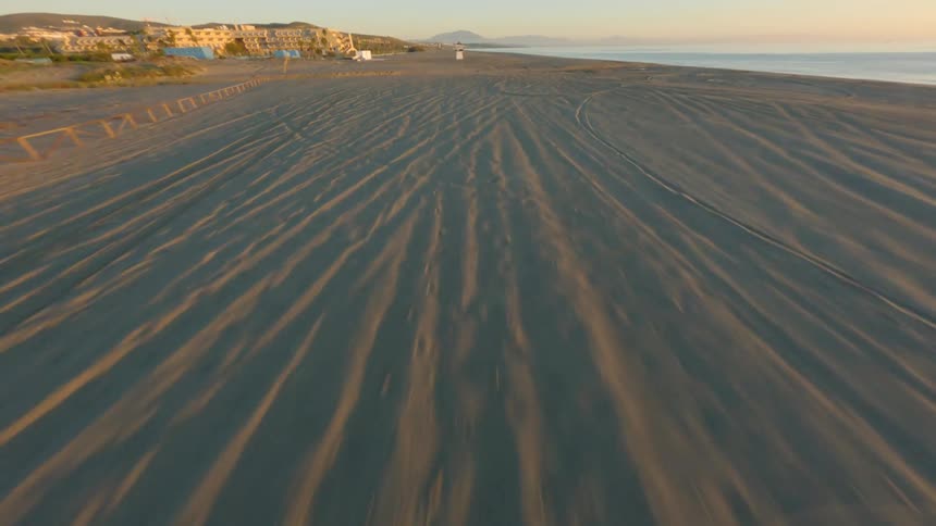 Aerial view of long beach at sunset next to the ocean