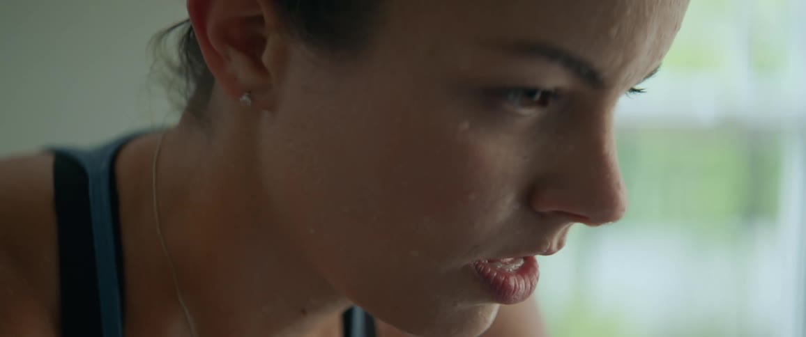 A woman is sweating as she exercises indoors