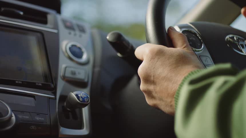Close up view of a person driving a car is displayed