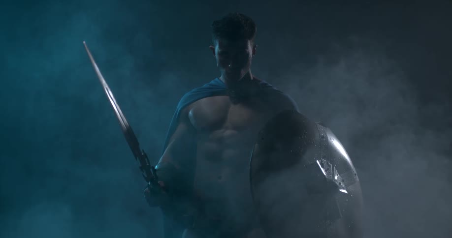 A warrior brandishing a sword and carrying a shield stands in fog