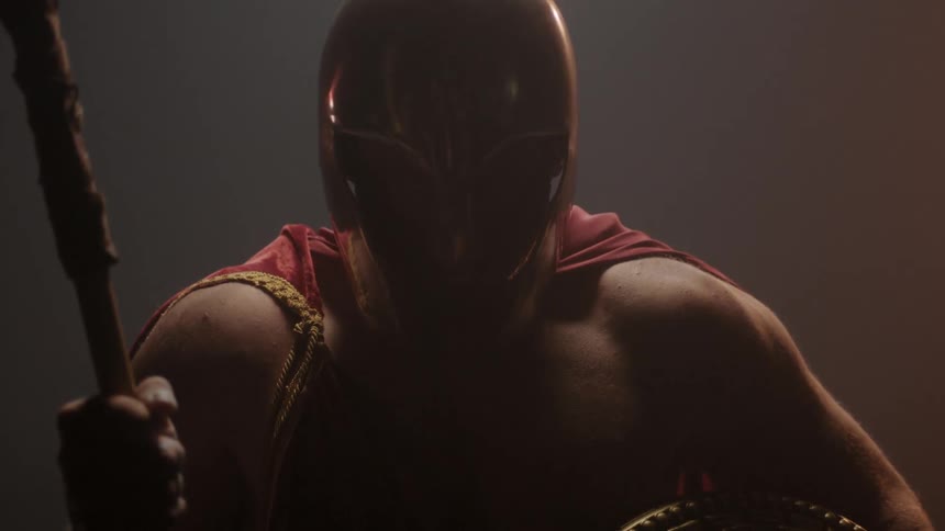 A man has a helmet and is holding a spear