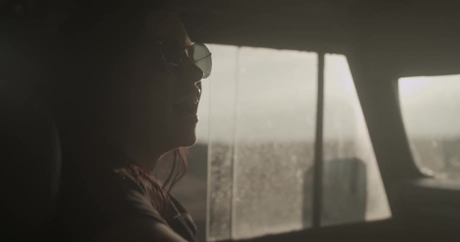 A woman is laughing in a vehicle