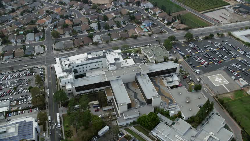An epic aerial orbit around Providence Holy Cross Medical Center in Mission Hills California showcasing the large medical center in Southern California during an overcast day