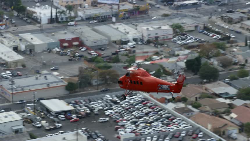 An aerial footage of a moving Sikorsky S58T helicopter over Pacoima California on a bright day