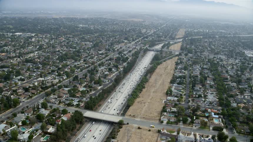 Aerial footage approaching the 118 Freeway in Granada Hills CA with views of residential neighborhoods and light traffic