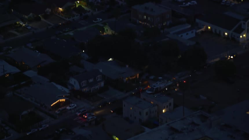 An LAPD helicopter is tracked at twilight while flying over Hollywood California in a aerial stock footage