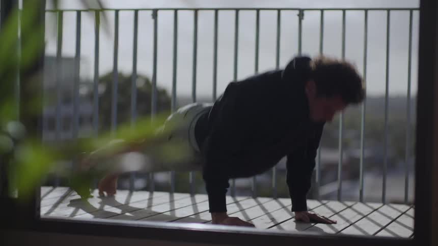 A man doing pushups on a balcony