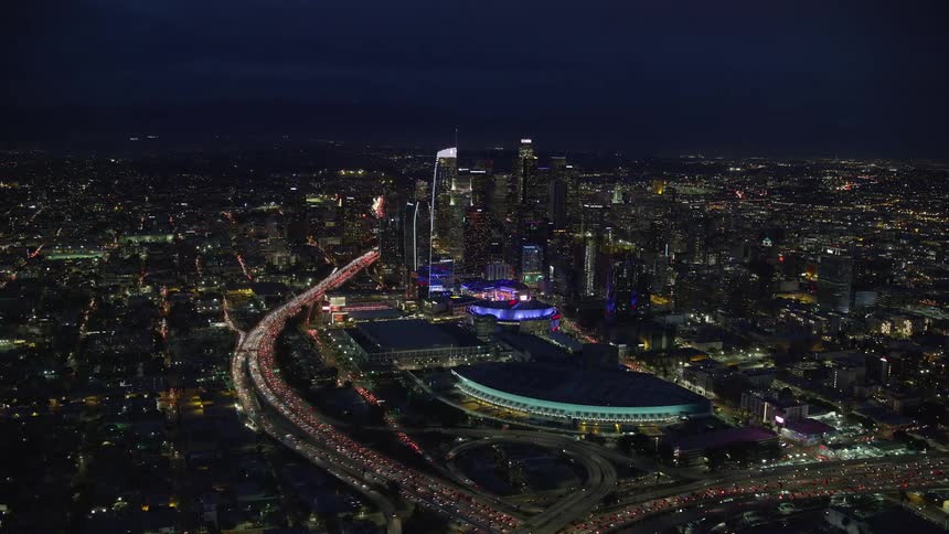  aerial footage shows heavy nighttime traffic on the 110 highway surrounded by skyscrapers Staples Center and the convention center in Los Angeles California