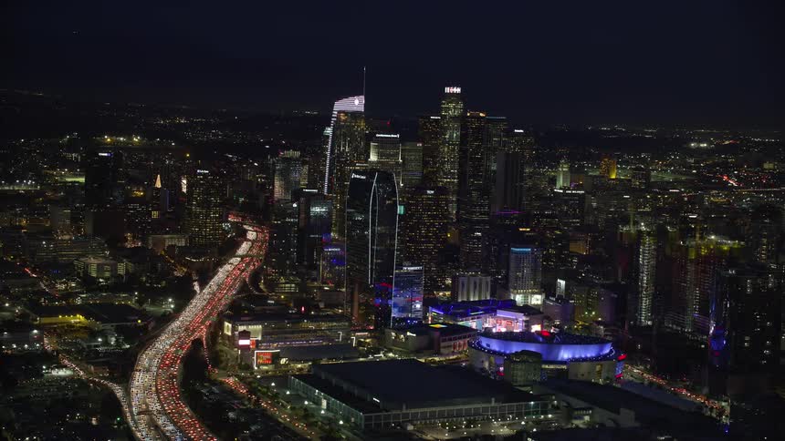 Nighttime view of heavy traffic on Highway 110 surrounded by skyscrapers and Staples Center shot from above in Downtown Los Angeles California