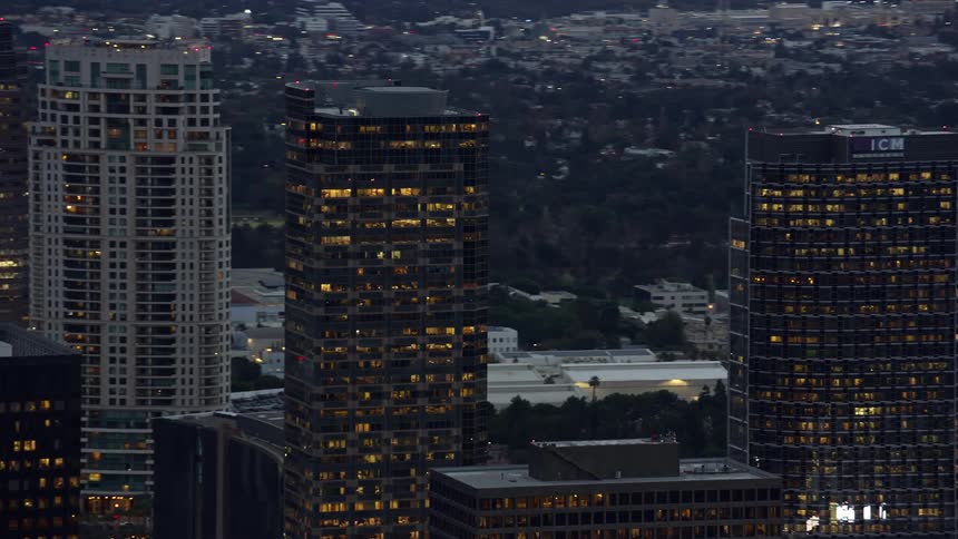 An evening aerial view of office and apartment buildings in Century City CA shot during twilight
