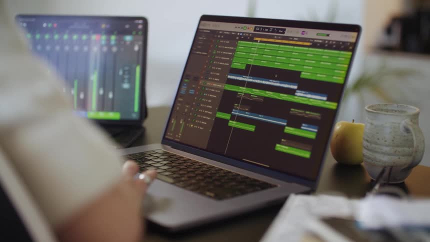 Two laptops on a surface with someone operating them