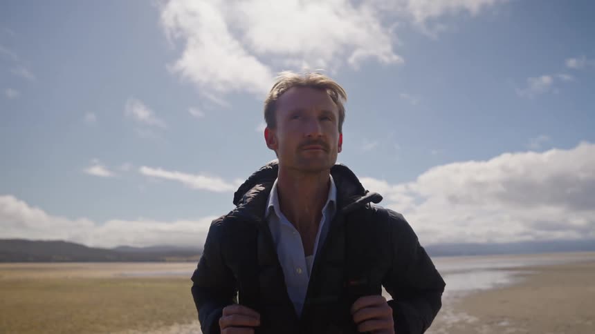 A man is hiking through a desert by himself