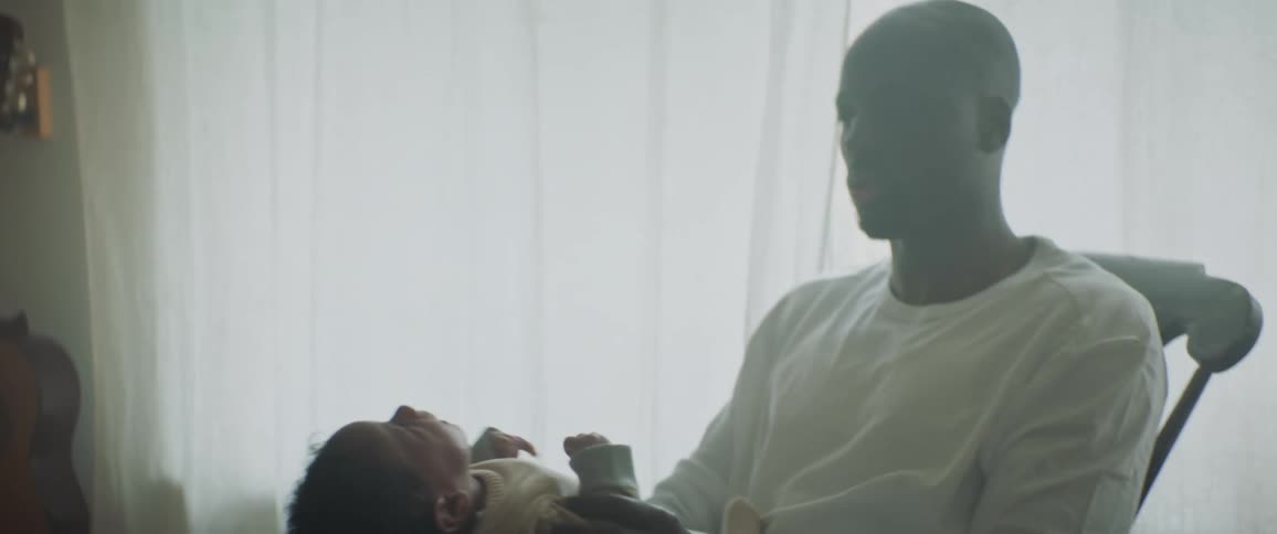 Father holds and coos to fussy baby while using a rocking chair