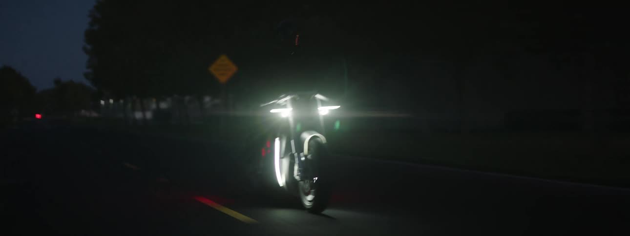 Man with helmet and jacket rides motorcycle on highway at night