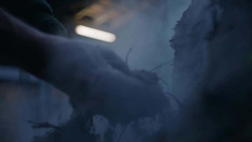 A persons hands handling steamy dirt as it falls through their fingers