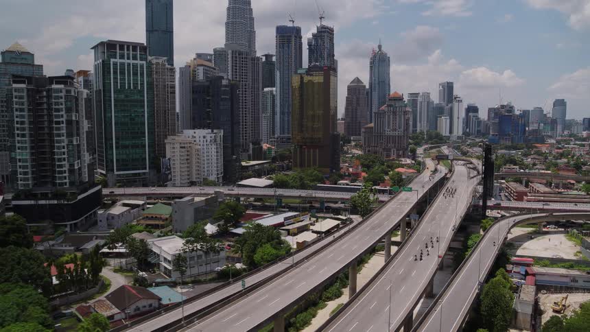 Steady traffic passes down a freeway through downtown