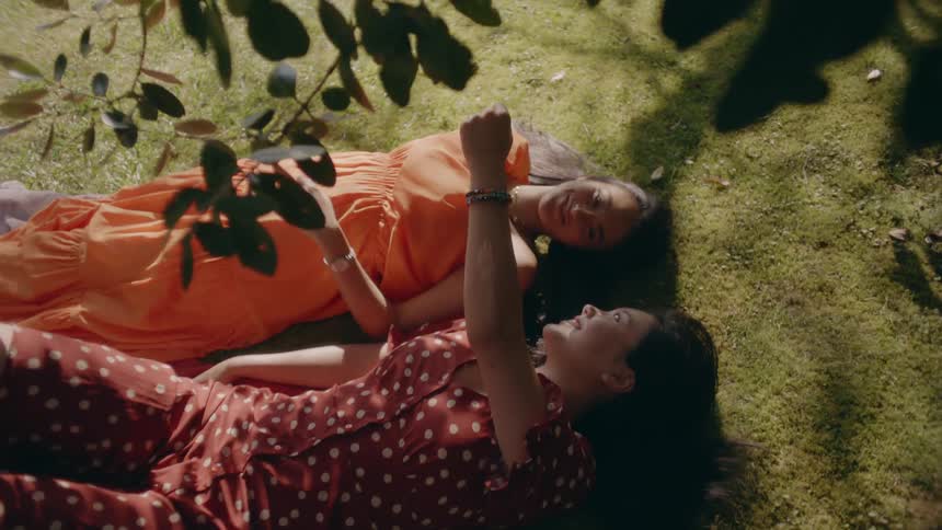 Two women lay in the grass