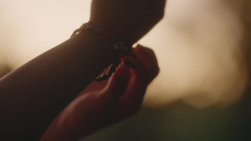 Girls wearing bracelets touches them with her fingers