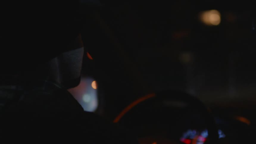 A man is driving at night