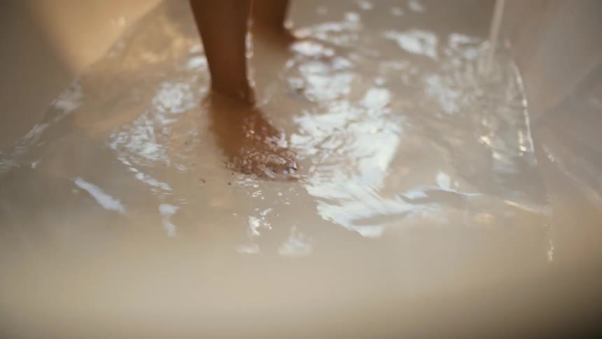Close up view of a person stepping into a shower
