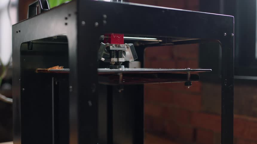A three dimensional printer moves around an object it is creating