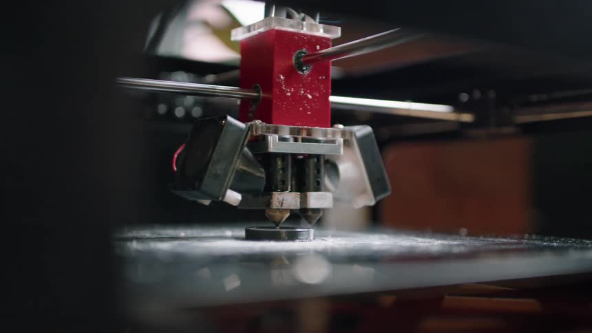 A three dimensional printer turns while creating an object