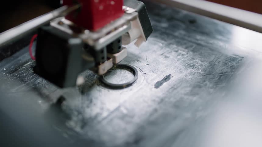 An up close of a machine going around in circles creating a 3d product