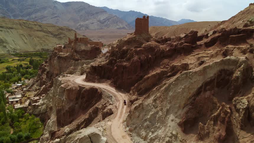 A person is riding their motorcycle along the mountainside