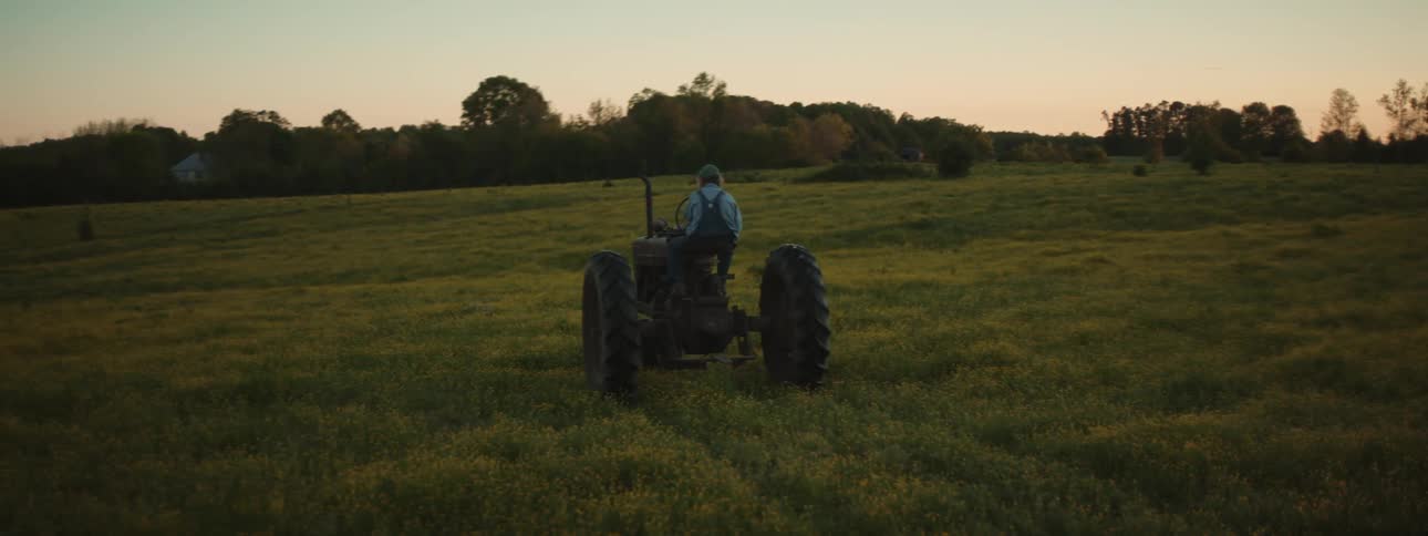 A farmer drives his tractor on the field