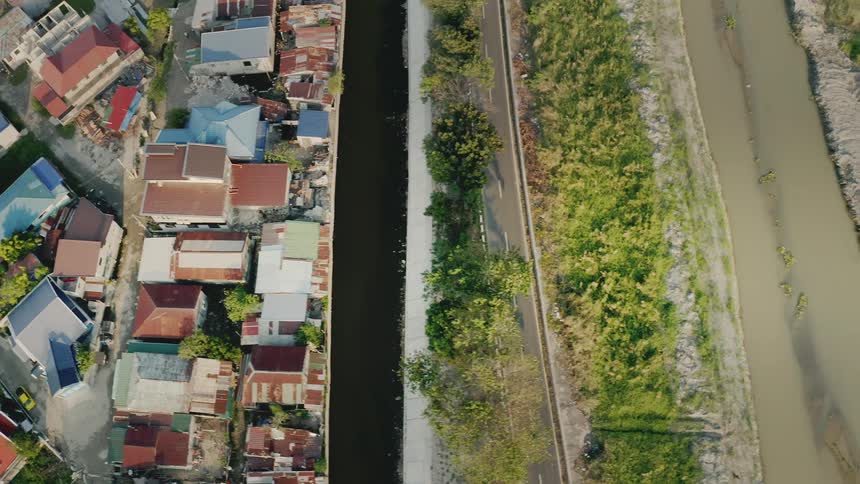 Aerial of colorful rooftops in neighborhood community next to vacant land