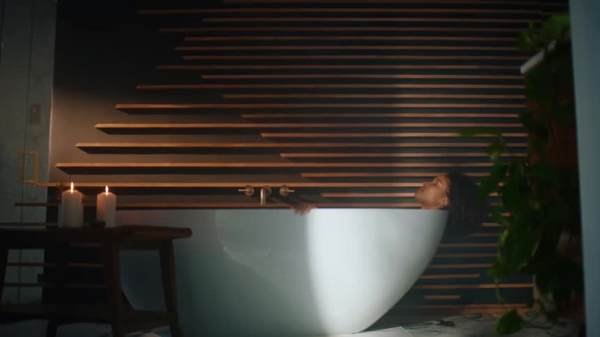 A woman is relaxing in a bathtub during the day