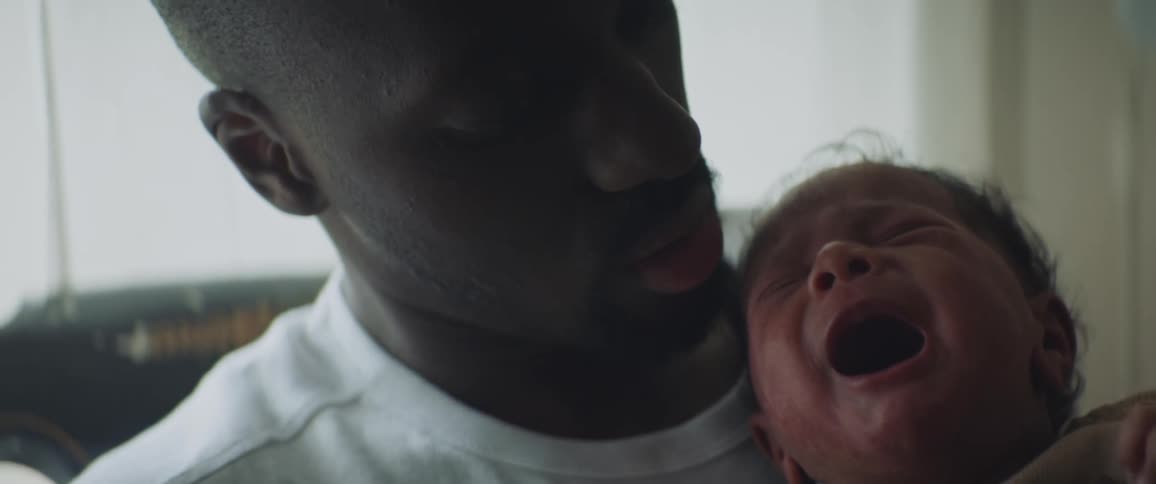 A father is holding his crying baby