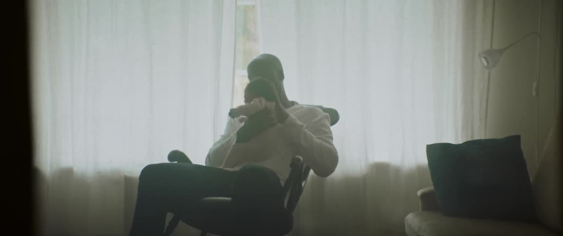 Father caring for a baby in a rocking chair in the living room