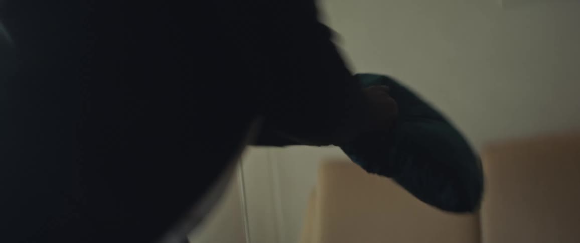 A child and father play fight with pillows laughing and smiling on the couch