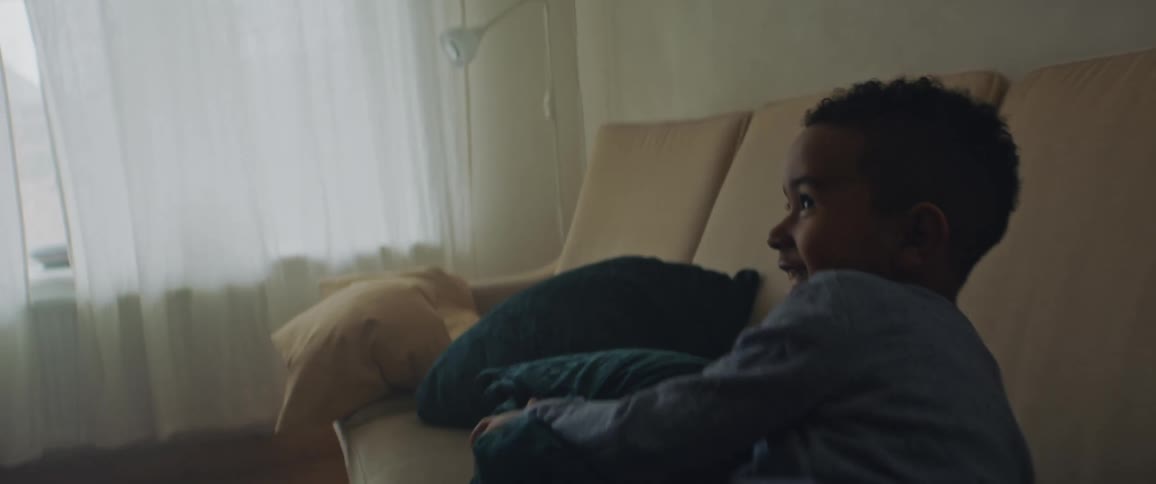 A father and son play in the living room