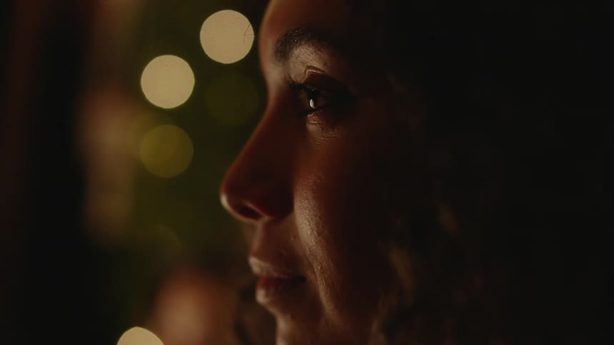 A closeup view of a young womans face as she sits still stares and thinks