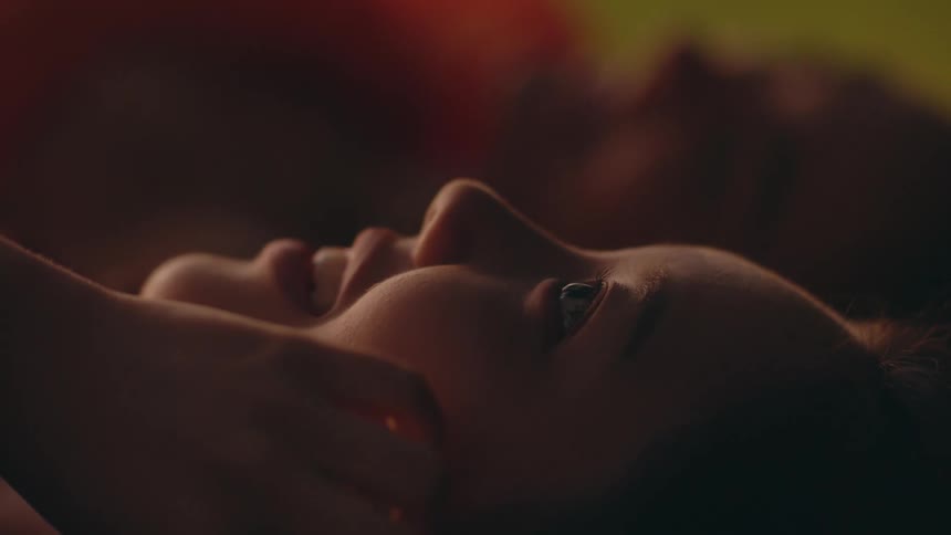 A man and woman laugh while lying on the floor side by side