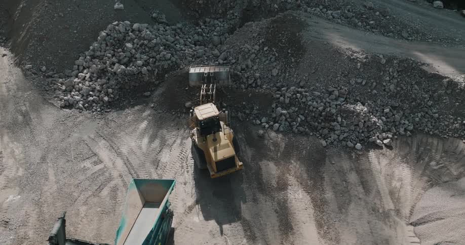 A construction site where a tractor is moving rocks and stones