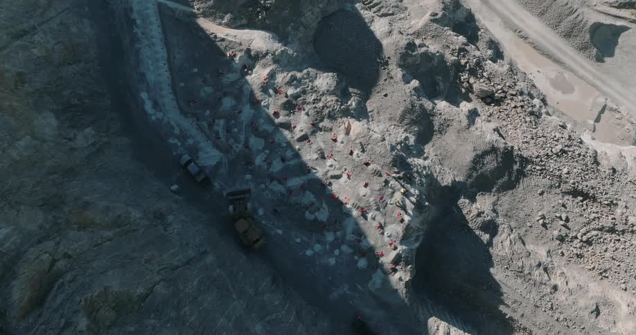 Aerial view of two bulldozers digger and excavator at the bottom of an excavation construction site